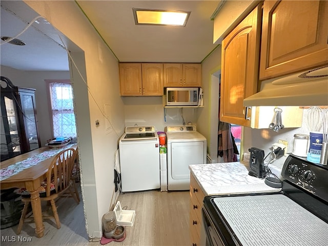 laundry room featuring laundry area, light wood-type flooring, and washing machine and clothes dryer