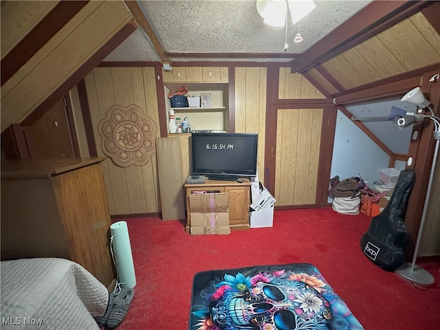 interior space featuring lofted ceiling with beams, wood walls, a textured ceiling, and carpet flooring