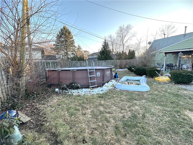 view of yard with a fenced in pool and fence