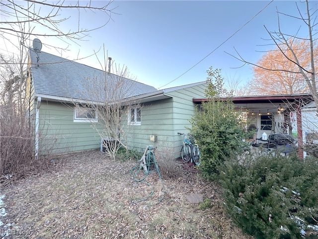 back of house featuring a shingled roof