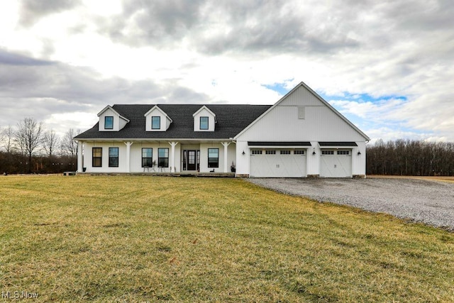 view of front of home with a porch, driveway, an attached garage, and a front yard