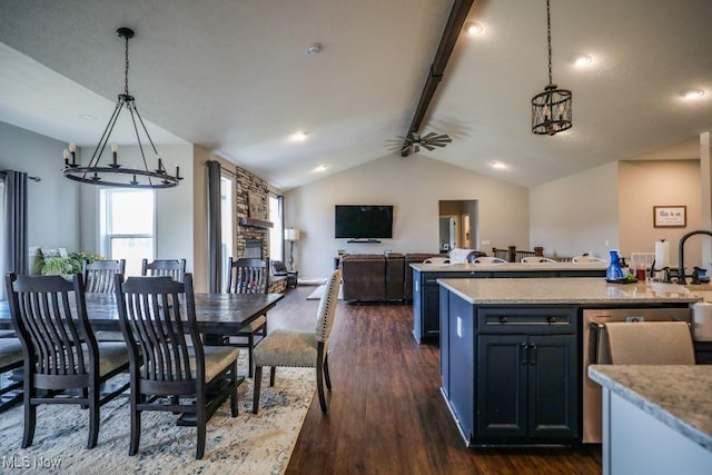 kitchen with dark wood-type flooring, pendant lighting, open floor plan, and vaulted ceiling