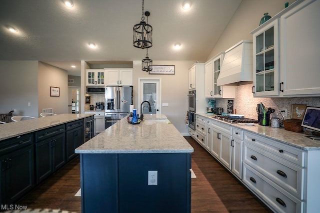 kitchen featuring decorative backsplash, appliances with stainless steel finishes, dark wood-type flooring, and a kitchen island with sink