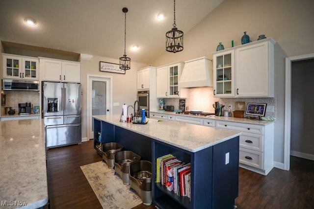 kitchen featuring stainless steel appliances, custom exhaust hood, and white cabinetry