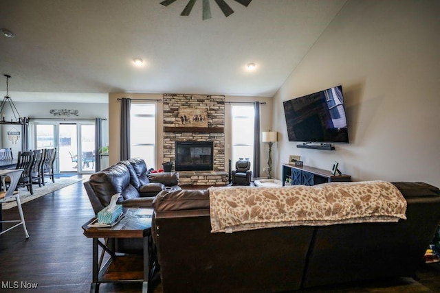 living room featuring ceiling fan, dark wood-type flooring, a fireplace, and vaulted ceiling