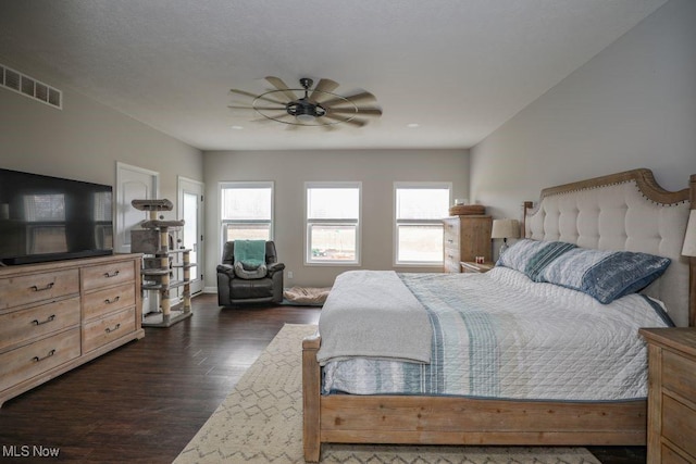 bedroom featuring visible vents, dark wood finished floors, and a ceiling fan