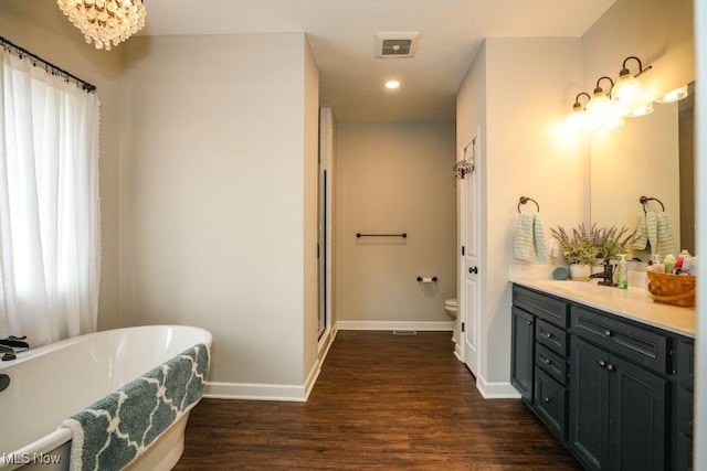 full bath with visible vents, baseboards, toilet, wood finished floors, and vanity