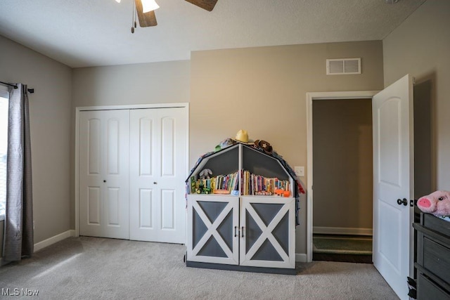 carpeted bedroom with a ceiling fan, baseboards, visible vents, and a closet