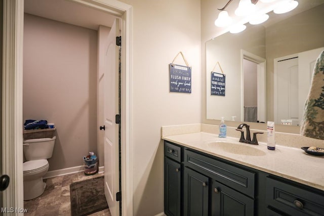 bathroom featuring vanity, a notable chandelier, toilet, and baseboards