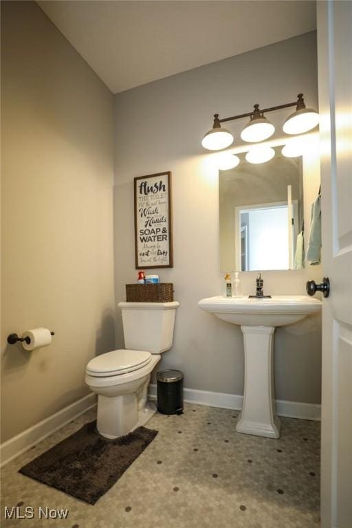 bathroom with toilet and baseboards