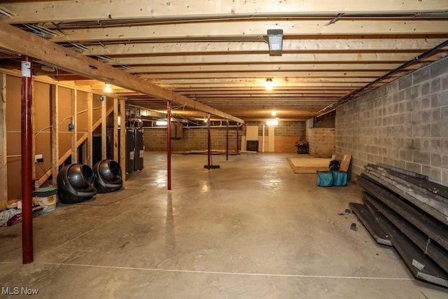 unfinished basement featuring concrete block wall