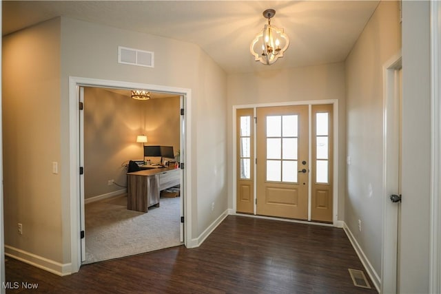 entrance foyer featuring visible vents, dark wood-type flooring, a notable chandelier, baseboards, and vaulted ceiling