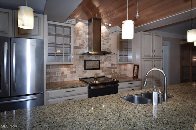 kitchen with tasteful backsplash, range with electric cooktop, freestanding refrigerator, wall chimney range hood, and a sink