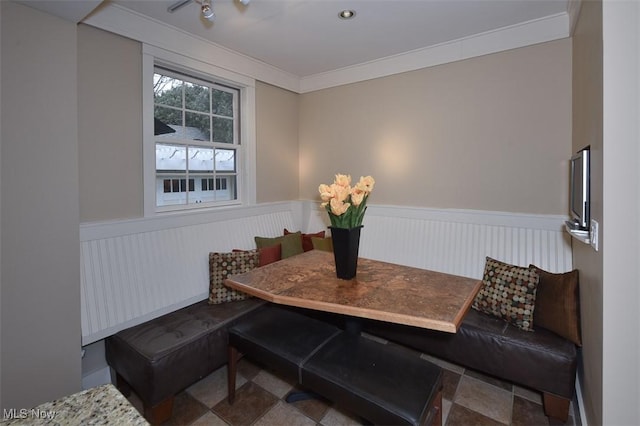 dining area with breakfast area, wainscoting, and ornamental molding