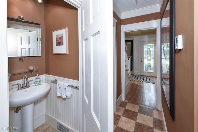 bathroom featuring wainscoting, a sink, and visible vents