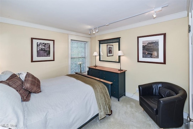 bedroom featuring crown molding, rail lighting, and light colored carpet