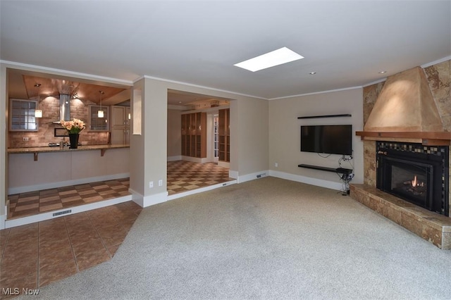 unfurnished living room with a large fireplace, visible vents, baseboards, tile patterned floors, and crown molding