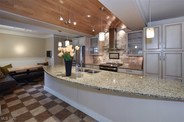 kitchen featuring decorative backsplash, wood ceiling, appliances with stainless steel finishes, wall chimney range hood, and a sink