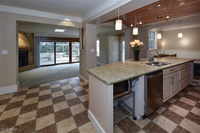 kitchen featuring light stone counters, stainless steel appliances, a fireplace, a sink, and open floor plan