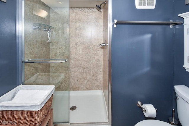 bathroom with toilet, a shower stall, and visible vents