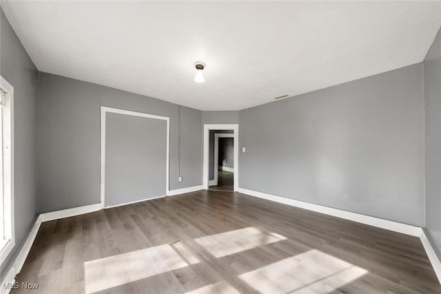 empty room featuring baseboards and wood finished floors