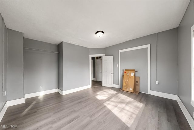 unfurnished bedroom featuring wood finished floors and baseboards