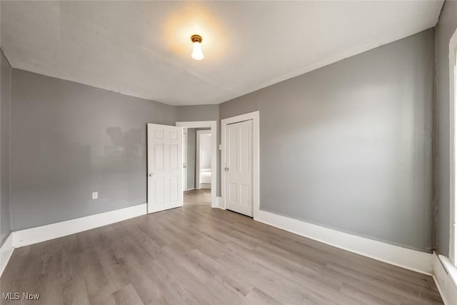 unfurnished room featuring baseboards and wood finished floors