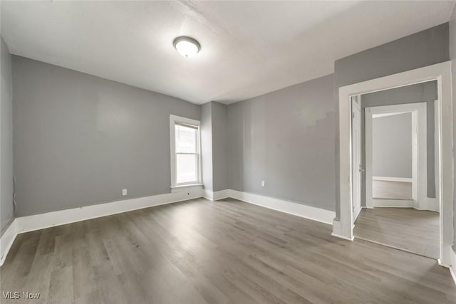 empty room featuring baseboards and wood finished floors