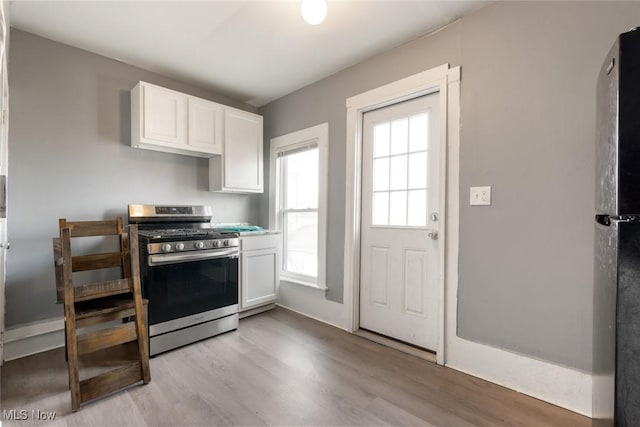 kitchen with light wood-style floors, white cabinets, and gas stove