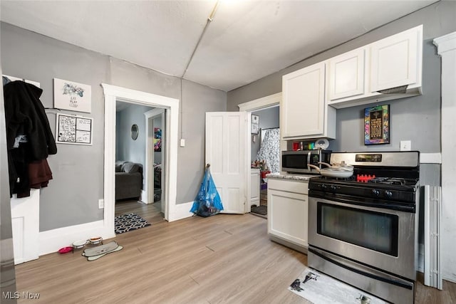 kitchen featuring light countertops, appliances with stainless steel finishes, light wood-style floors, white cabinetry, and baseboards