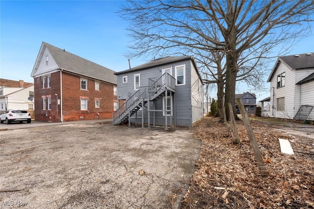 back of house featuring stairs