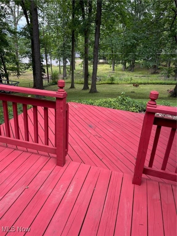 wooden deck with a water view and a lawn