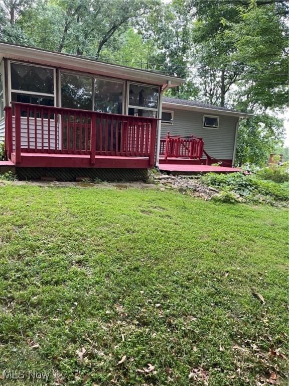 back of house with a lawn and a wooden deck