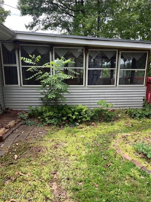 view of property exterior featuring a sunroom