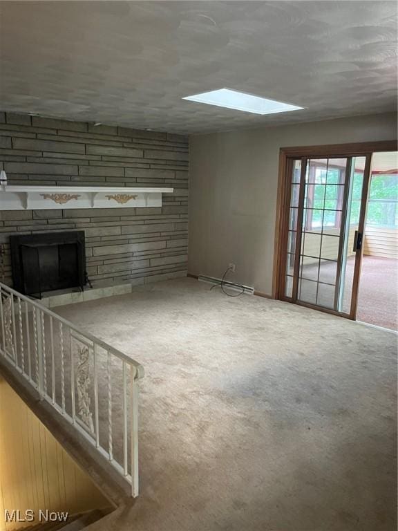 unfurnished living room featuring carpet floors, a skylight, and a fireplace