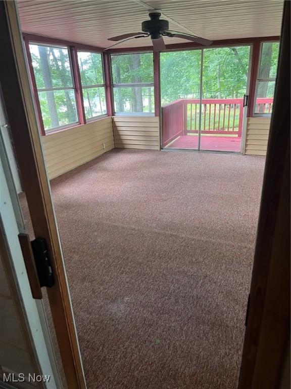 unfurnished sunroom featuring a ceiling fan