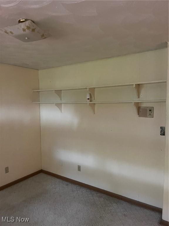 carpeted empty room featuring baseboards