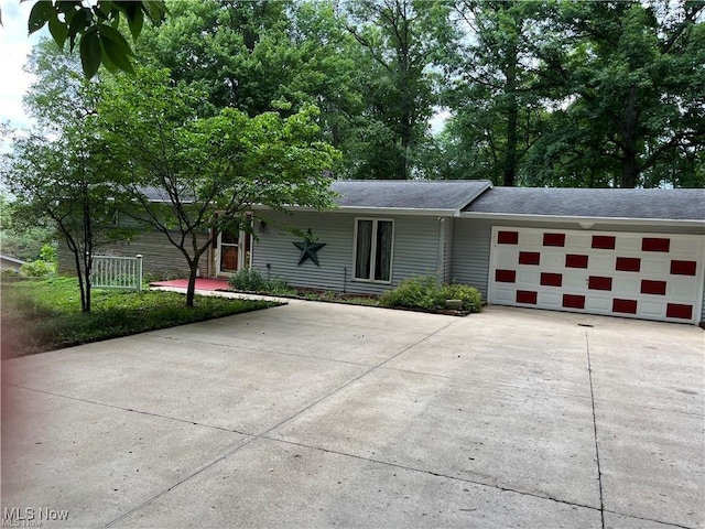 ranch-style house featuring concrete driveway and an attached garage