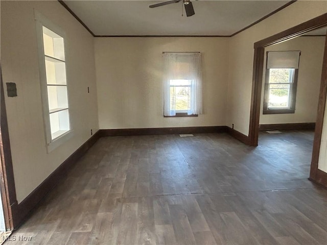 empty room featuring plenty of natural light, crown molding, and wood finished floors