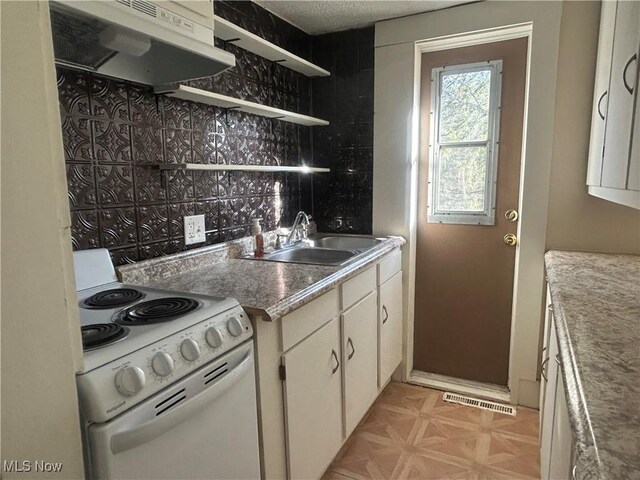 kitchen with visible vents, electric stove, white cabinetry, a sink, and exhaust hood