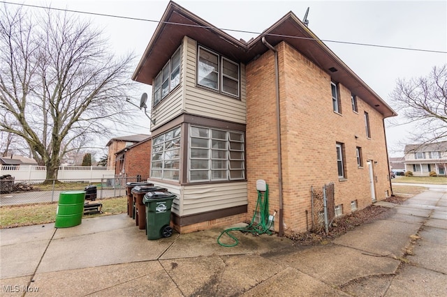 view of home's exterior with fence and brick siding