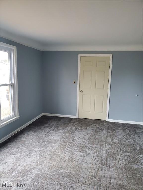 unfurnished room with carpet floors, baseboards, and ornamental molding