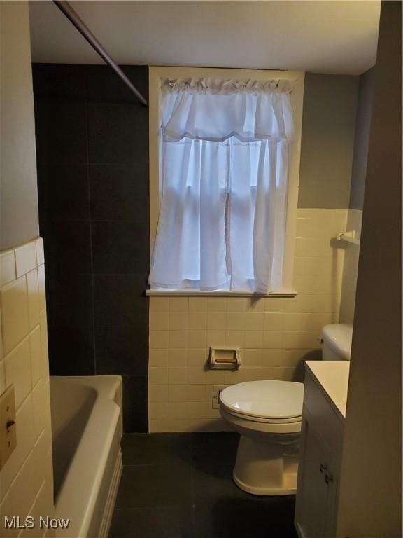 full bath featuring toilet, tile patterned flooring, tile walls, and vanity