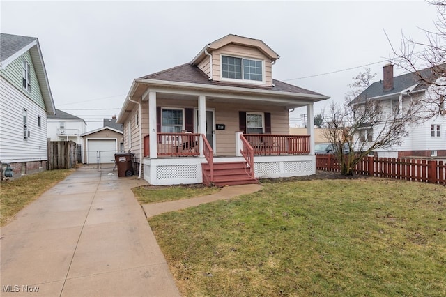 bungalow featuring a front yard, covered porch, fence, and an outbuilding