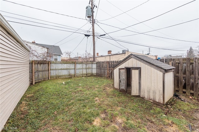 view of yard featuring an outbuilding, a fenced backyard, and a storage unit