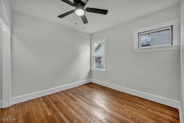 unfurnished room featuring wood-type flooring, baseboards, and a ceiling fan