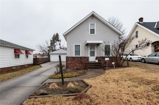 bungalow-style house with an outbuilding, brick siding, a detached garage, and fence