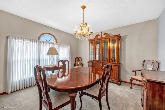 dining area featuring a chandelier, light carpet, and baseboards