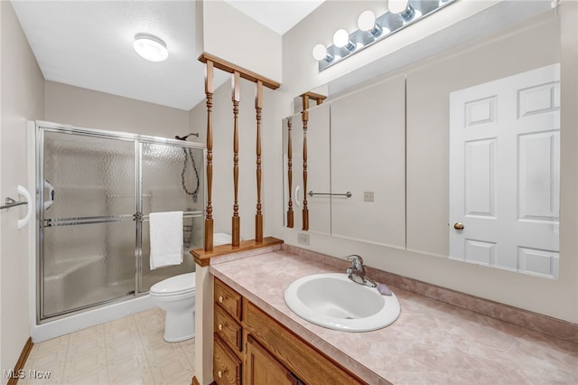 bathroom featuring vanity, a shower stall, toilet, and tile patterned floors