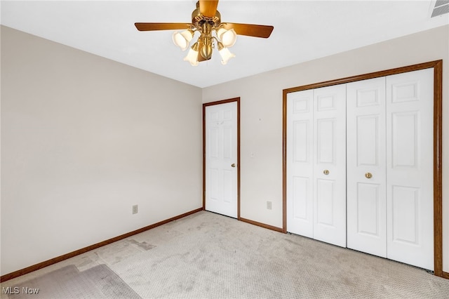 unfurnished bedroom featuring light carpet, a ceiling fan, visible vents, baseboards, and a closet